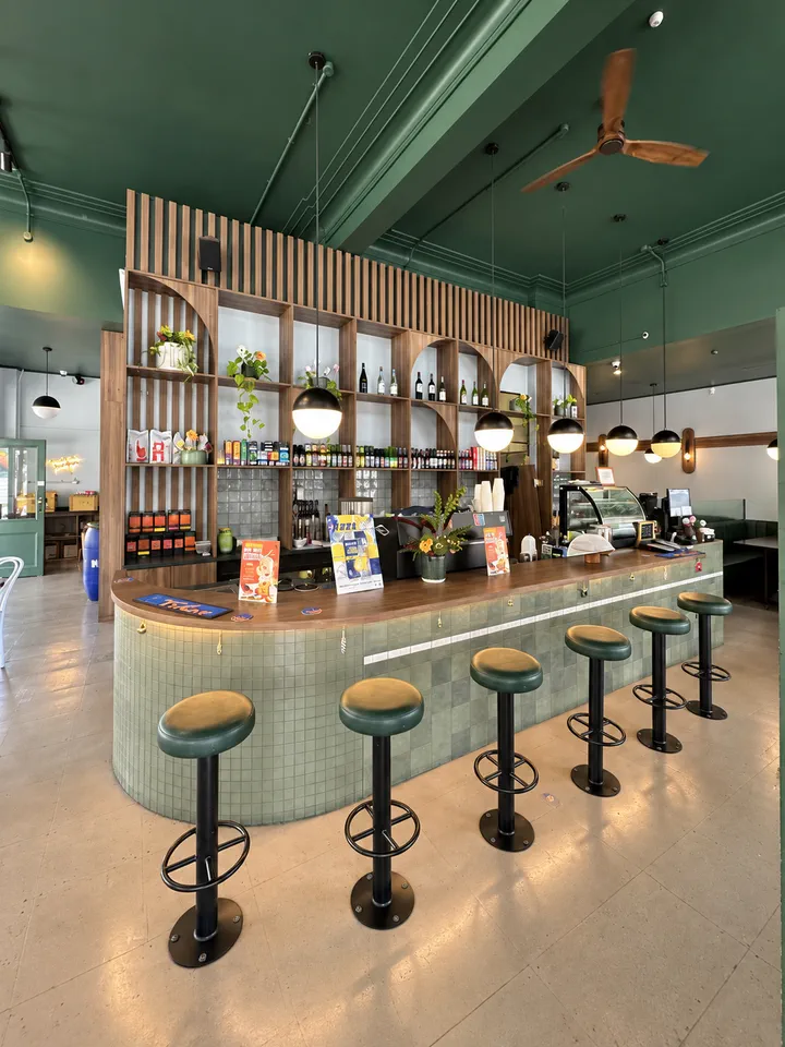 Green-tiled bar with pendant lights and stools inside Hood Street Bistro